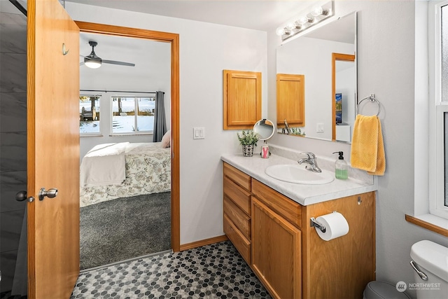 bathroom featuring toilet, vanity, and ceiling fan