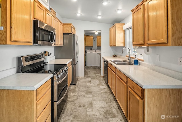 kitchen with stainless steel appliances, sink, washer and dryer, and vaulted ceiling