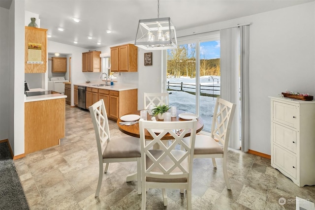 dining space featuring sink, washer and clothes dryer, and vaulted ceiling