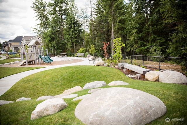 view of home's community featuring a playground and a lawn