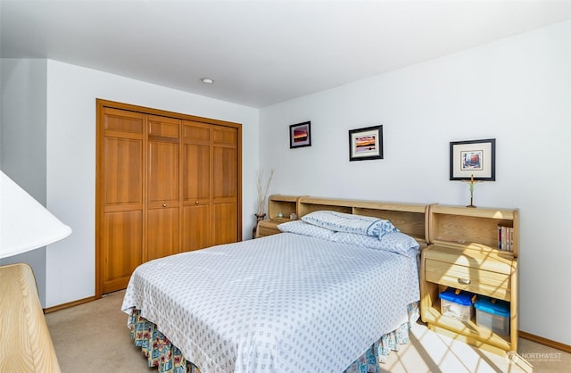 bedroom featuring light colored carpet and a closet