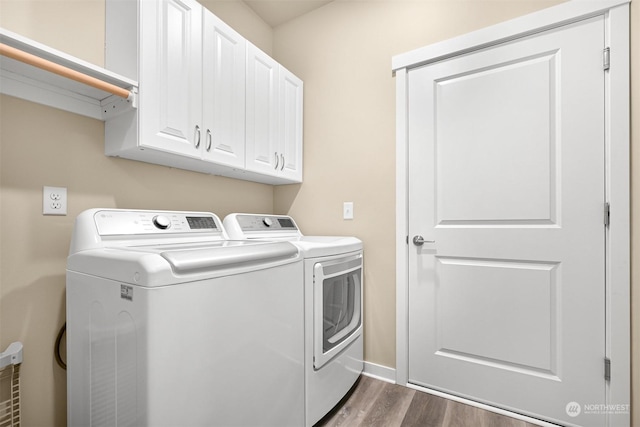 laundry room featuring washer and dryer, dark wood-type flooring, and cabinets