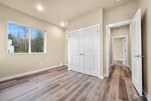 unfurnished bedroom featuring light hardwood / wood-style flooring and a closet