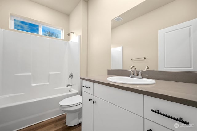 full bathroom with shower / washtub combination, hardwood / wood-style floors, vanity, and toilet