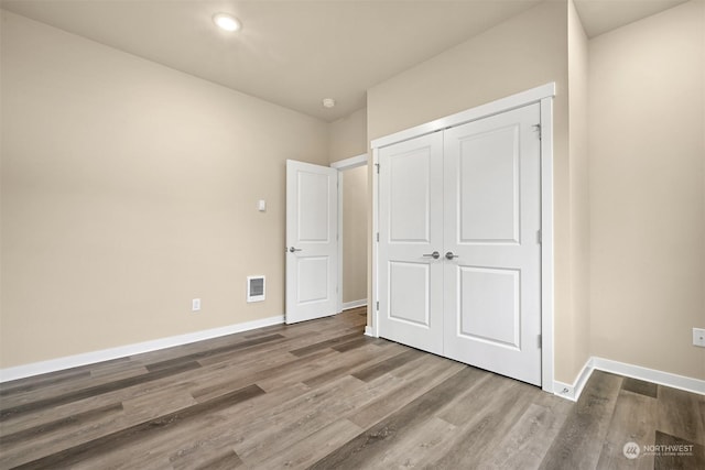 unfurnished bedroom featuring hardwood / wood-style flooring and a closet