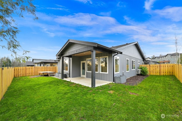 back of house with a patio area and a yard