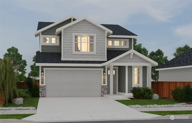 craftsman house featuring stone siding, concrete driveway, fence, and an attached garage