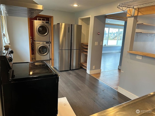 washroom featuring dark hardwood / wood-style floors and stacked washer and clothes dryer