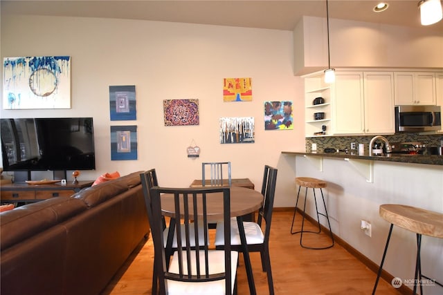 dining space featuring light hardwood / wood-style floors and sink