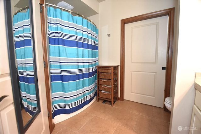 bathroom with toilet, vanity, tile patterned flooring, and curtained shower