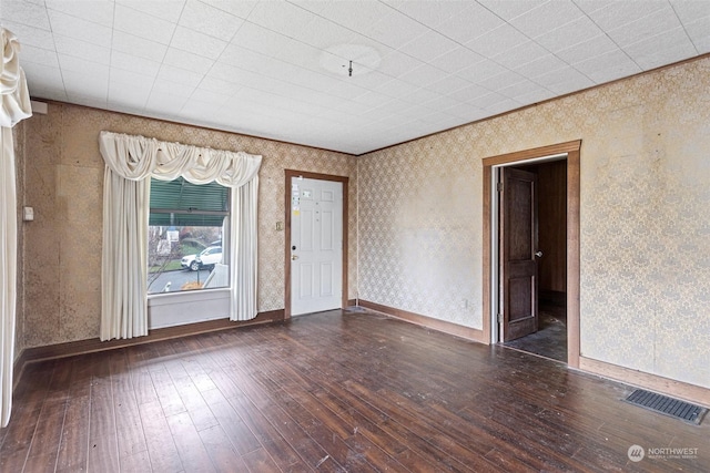 unfurnished room featuring dark wood-type flooring and ornamental molding