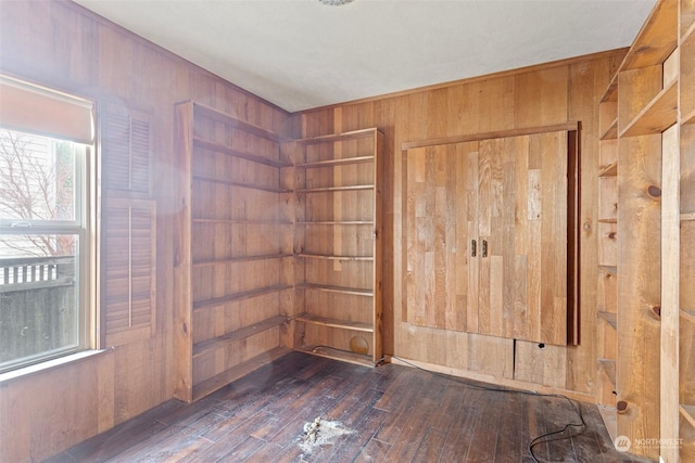 spare room featuring dark wood-type flooring and wood walls