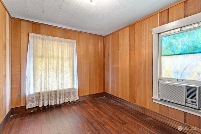 empty room with cooling unit, dark wood-type flooring, and wooden walls