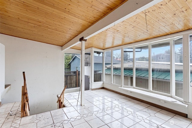 unfurnished sunroom featuring wood ceiling, lofted ceiling with beams, and decorative columns