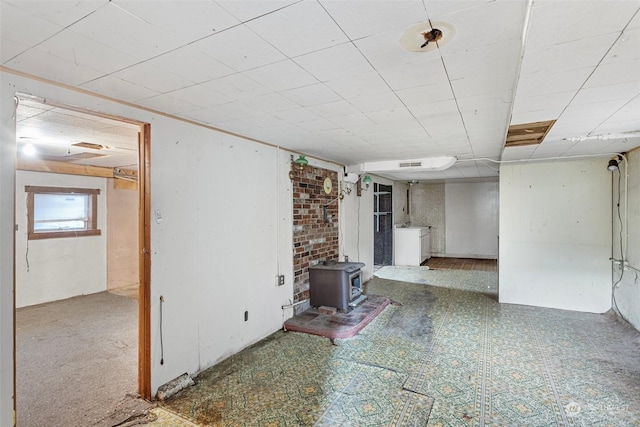 unfurnished living room featuring washer / dryer and a wood stove