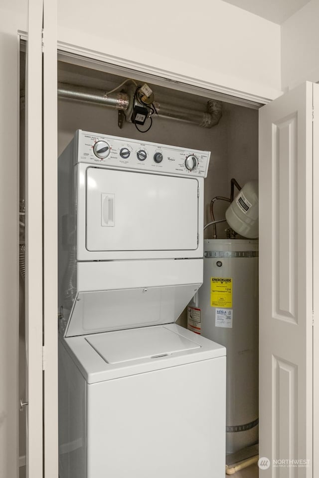 laundry room with water heater and stacked washer and clothes dryer