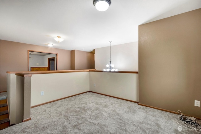 spare room with a chandelier and carpet