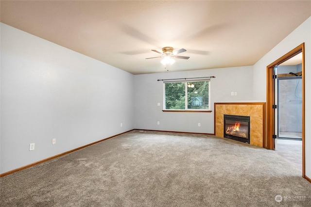 unfurnished living room featuring a tile fireplace, carpet flooring, and ceiling fan