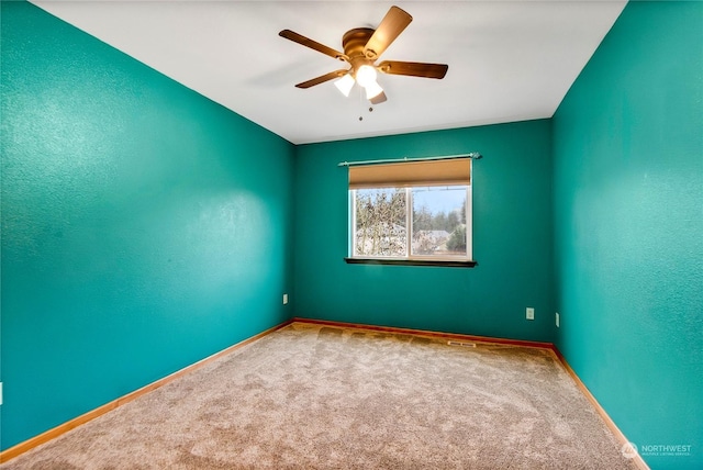 carpeted spare room featuring ceiling fan