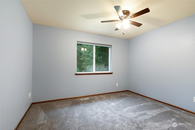 carpeted spare room with ceiling fan