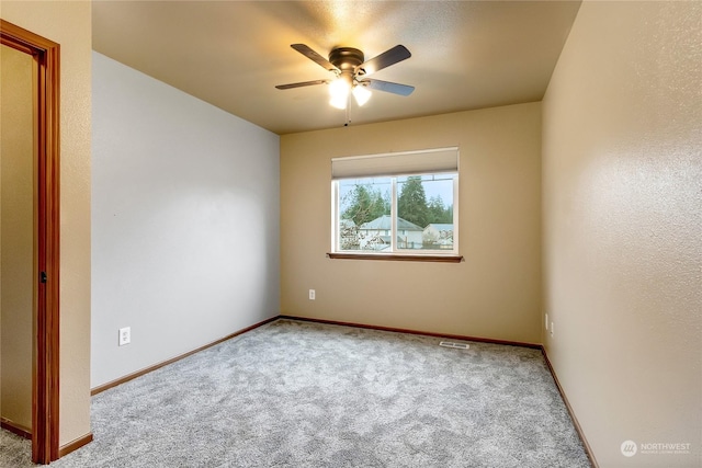 carpeted spare room with ceiling fan