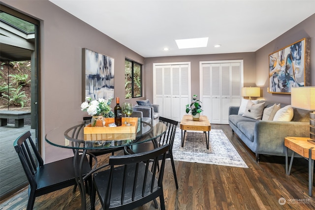 dining area featuring a skylight and dark hardwood / wood-style floors