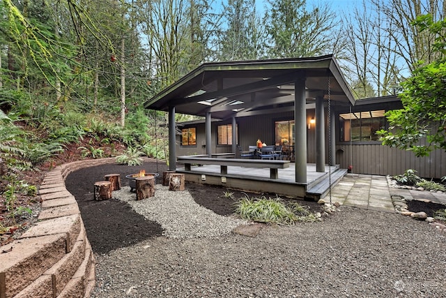 rear view of property with an outdoor fire pit and a wooden deck