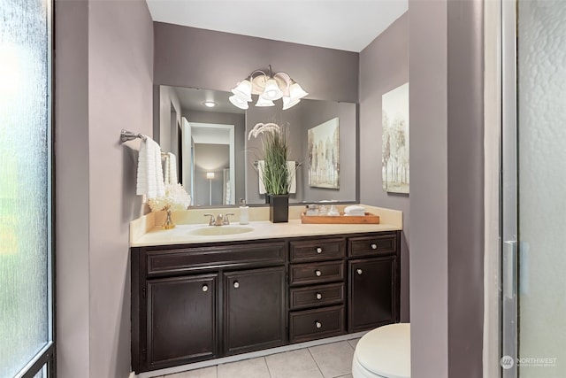 bathroom with toilet, tile patterned flooring, a notable chandelier, and vanity