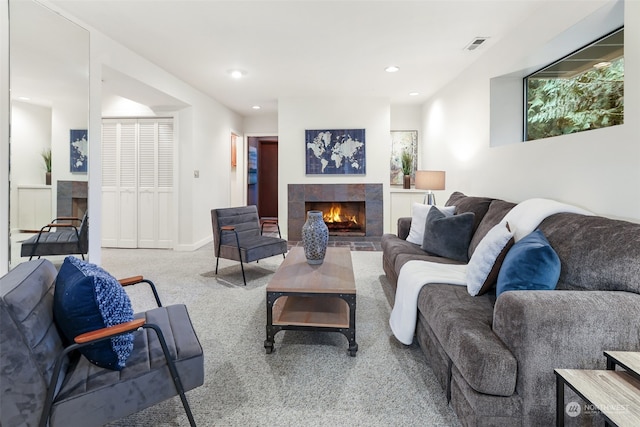 living room with a tiled fireplace and carpet flooring