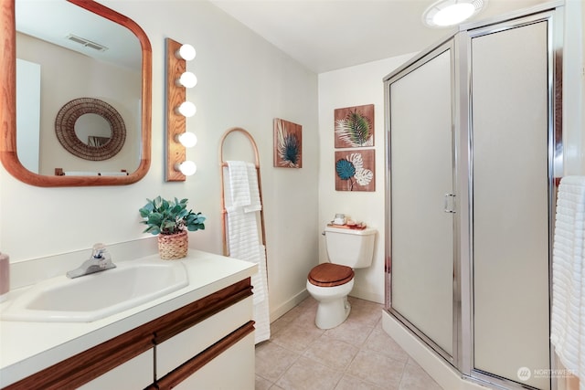 bathroom with toilet, vanity, tile patterned floors, and a shower with shower door