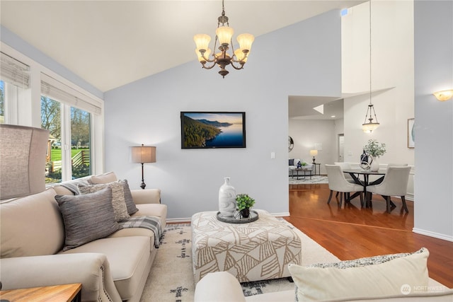 living room with hardwood / wood-style flooring, vaulted ceiling, and a notable chandelier