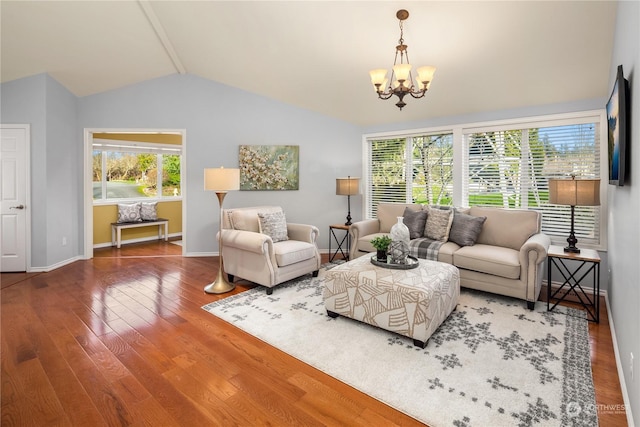 living room with hardwood / wood-style flooring, vaulted ceiling, and a notable chandelier