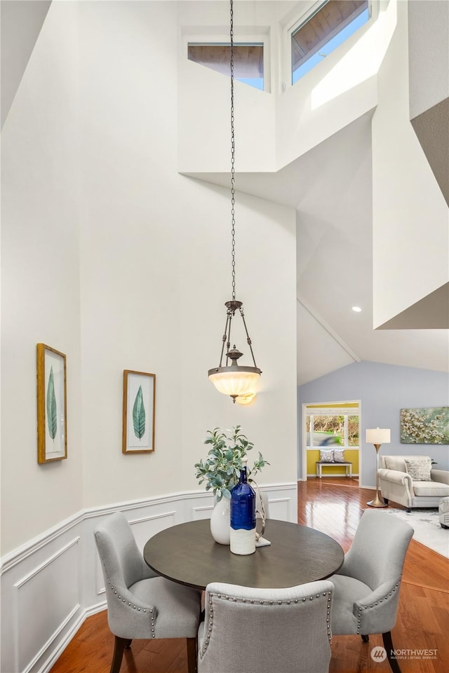 dining space featuring vaulted ceiling and hardwood / wood-style floors