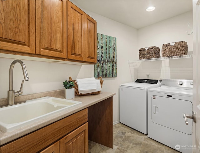 laundry area featuring cabinets, washer and dryer, and sink