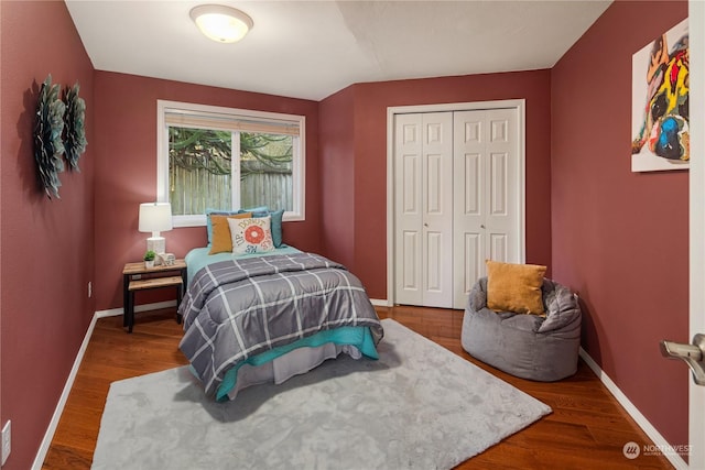 bedroom with dark hardwood / wood-style flooring and a closet