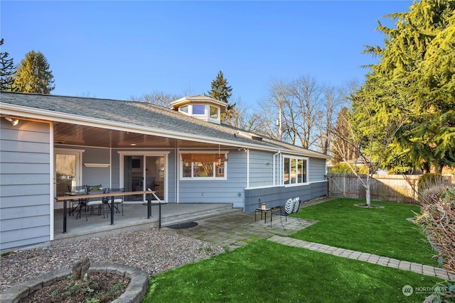 back of property featuring a patio and a lawn