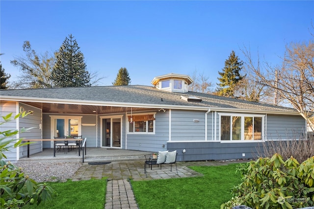 rear view of property featuring a lawn and a patio