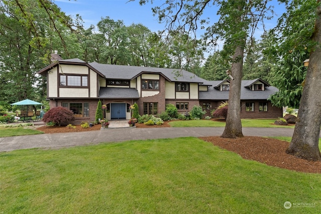 tudor-style house featuring a front lawn