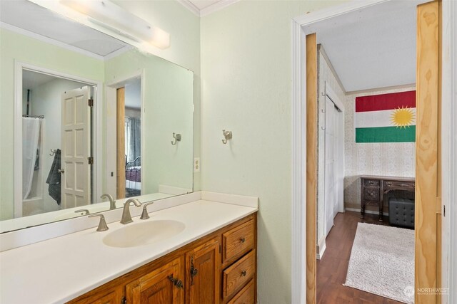 bathroom featuring wood-type flooring, vanity, and ornamental molding