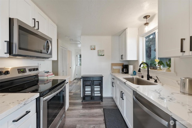 kitchen featuring light stone countertops, white cabinetry, sink, and stainless steel appliances