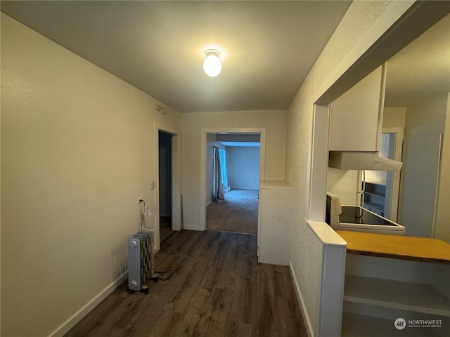 hall with radiator heating unit and dark hardwood / wood-style floors