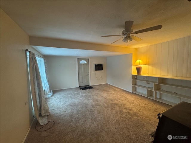 unfurnished living room featuring carpet and ceiling fan