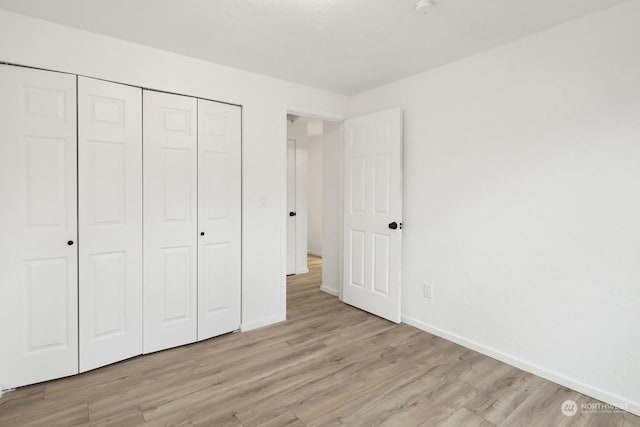 unfurnished bedroom with light hardwood / wood-style floors and a closet