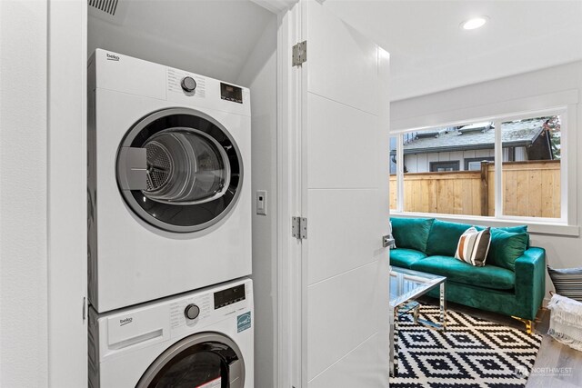 washroom featuring stacked washer / drying machine