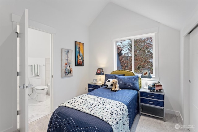 bedroom featuring lofted ceiling and ensuite bathroom