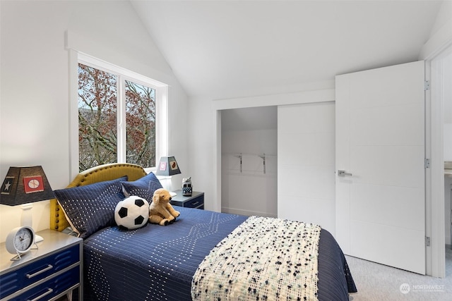 bedroom with vaulted ceiling and light colored carpet