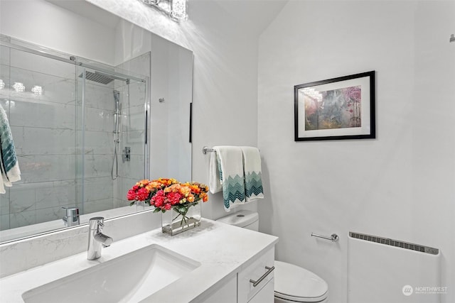 bathroom with vanity, radiator heating unit, an enclosed shower, and toilet