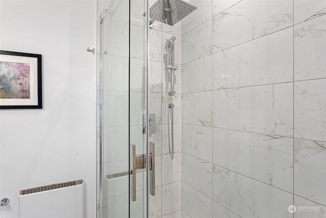 bathroom featuring a shower with door and radiator