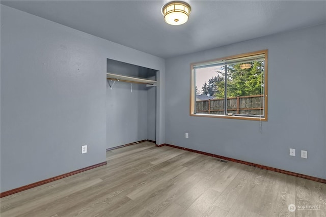 unfurnished bedroom with light wood-type flooring and a closet