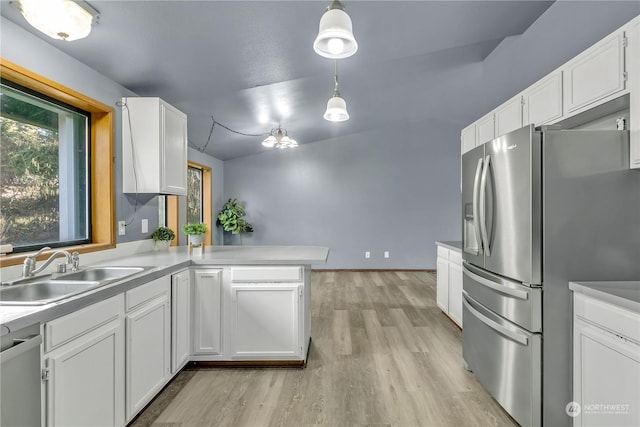 kitchen featuring white cabinets, sink, hanging light fixtures, appliances with stainless steel finishes, and kitchen peninsula